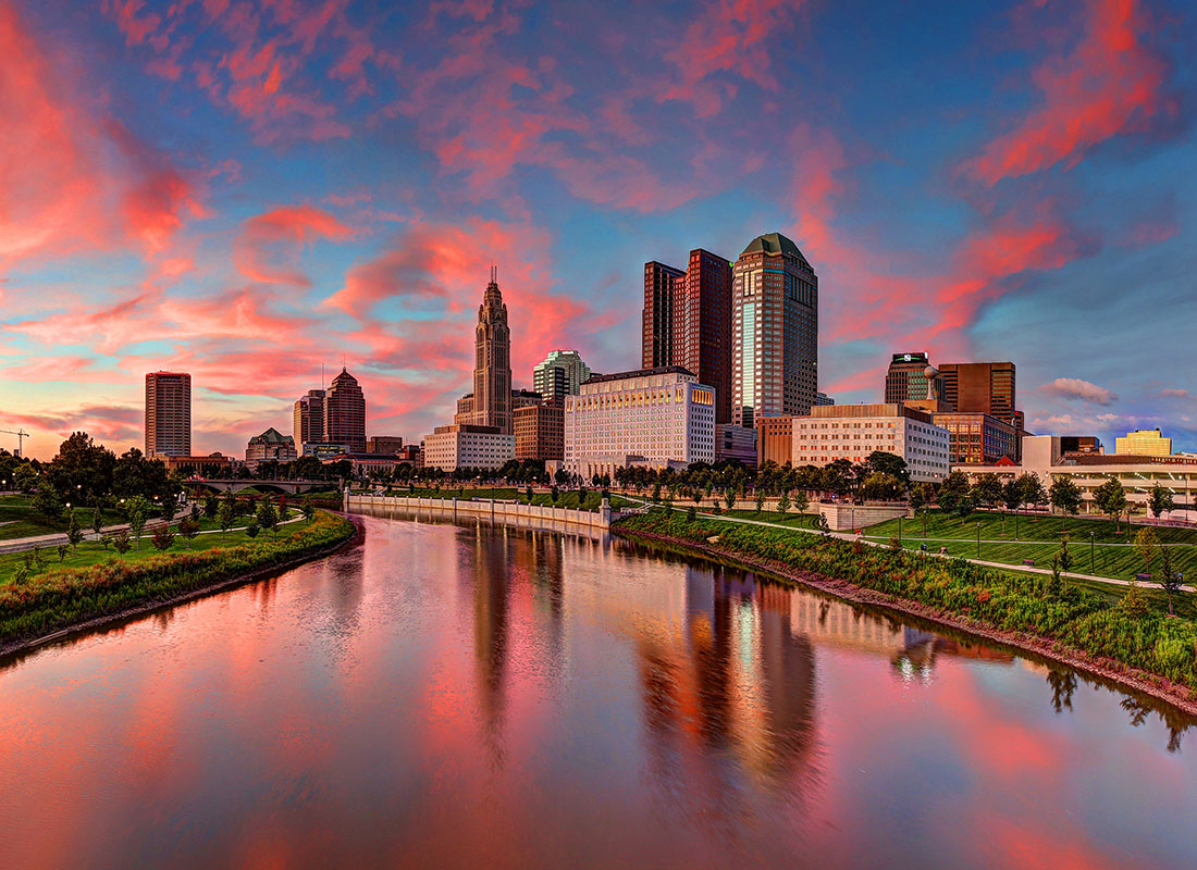 Insurance Solutions - Aerial View of Commercial Buildings in Columbus Ohio by the River Against a Colorful Red and Blue Sunset Sky